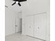 Bright bedroom featuring tile floors, ceiling fan, and closet doors at 8456 Se 164Th Pl, Summerfield, FL 34491