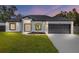 Beautiful home featuring a two-car garage, manicured lawn, and modern architectural design at 8456 Se 164Th Pl, Summerfield, FL 34491
