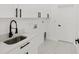 Well-lit laundry room with white cabinets, stainless steel sink, and modern fixtures at 8456 Se 164Th Pl, Summerfield, FL 34491
