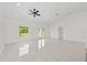 Spacious living room featuring white tile floors, neutral walls, a modern ceiling fan, and ample natural light at 8456 Se 164Th Pl, Summerfield, FL 34491