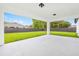 Open patio overlooking the fenced backyard with lush green grass and trees at 8456 Se 164Th Pl, Summerfield, FL 34491