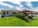 Landscaped backyard featuring a gazebo, manicured lawn, lush shrubs, and patio furniture at 9886 Sw 104Th Ave, Ocala, FL 34481