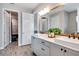 Bathroom with double vanity, a large framed mirror, wood-look flooring, and white paneled doors at 9886 Sw 104Th Ave, Ocala, FL 34481