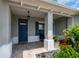 Charming front porch with brick pavers, a dark blue door, and a comfortable seating area at 9886 Sw 104Th Ave, Ocala, FL 34481