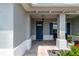 Charming front porch with brick pavers, a dark blue door, and beautiful plants and chairs at 9886 Sw 104Th Ave, Ocala, FL 34481