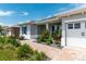 Charming home with lush landscaping leading to the entryway and a glimpse of the garage at 9886 Sw 104Th Ave, Ocala, FL 34481