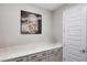 Hallway with gray cabinets, white countertops, a large painting, and a white door at 9886 Sw 104Th Ave, Ocala, FL 34481