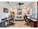 Spacious home office featuring two workstations, neutral paint, modern ceiling fan, and a comfortable sofa at 9886 Sw 104Th Ave, Ocala, FL 34481