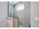 Shower featuring modern gray tiles, a glass enclosure, and a shower head, with a window for natural light at 9886 Sw 104Th Ave, Ocala, FL 34481