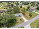 An aerial view of a well-maintained house, showcasing the roof, driveway, and surrounding mature trees at 106 Pine Trce, Ocala, FL 34472