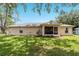 The home features a screened lanai and green grass in the backyard at 106 Pine Trce, Ocala, FL 34472
