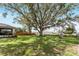 Open backyard with mature tree, play set and lush green grass at 106 Pine Trce, Ocala, FL 34472
