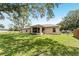 A backyard view of the property, showcasing the screened lanai, and a well-maintained lawn at 106 Pine Trce, Ocala, FL 34472