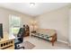 Bedroom with desk and futon, carpet flooring, and natural light from a window overlooking the yard at 106 Pine Trce, Ocala, FL 34472