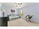 Comfortable bedroom features a ceiling fan, a large window, and a reading chair at 106 Pine Trce, Ocala, FL 34472
