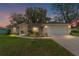 Charming single-story home with a well-manicured lawn and a two-car garage at twilight at 106 Pine Trce, Ocala, FL 34472