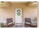 Close-up of a white front door with a sun-shaped wreath and welcome mat at 106 Pine Trce, Ocala, FL 34472