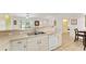 Bright kitchen with stainless steel sink, white cabinets and appliances, and tile flooring at 106 Pine Trce, Ocala, FL 34472