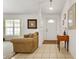 Bright living room featuring tile flooring and a cozy couch with natural light at 106 Pine Trce, Ocala, FL 34472