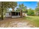 Rear exterior view with a screened in porch and a lush green lawn at 10671 Ne 152Nd Ln, Fort Mc Coy, FL 32134