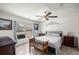Cozy bedroom with a wooden bench, a ceiling fan, and natural light from a window at 10671 Ne 152Nd Ln, Fort Mc Coy, FL 32134