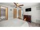 Comfortable bedroom with TV, fan, wood flooring, and ensuite bathroom access at 10671 Ne 152Nd Ln, Fort Mc Coy, FL 32134