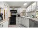 Well-lit kitchen with white cabinetry, modern black appliances, and durable countertops at 10671 Ne 152Nd Ln, Fort Mc Coy, FL 32134