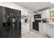 Bright kitchen featuring modern black appliances, white cabinets, and wood-look flooring at 10671 Ne 152Nd Ln, Fort Mc Coy, FL 32134