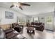 Cozy living room featuring wood laminate floors, neutral paint, and comfortable leather furniture at 10671 Ne 152Nd Ln, Fort Mc Coy, FL 32134