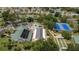 Enjoy this aerial view of the community clubhouse, pool and spa, tennis courts, and meticulously landscaped grounds at 11326 Se 175Th Pl, Summerfield, FL 34491