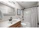 Bathroom features a sink, vanity, toilet and a shower-tub combination with a curtain at 11326 Se 175Th Pl, Summerfield, FL 34491