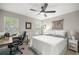 Bedroom features a ceiling fan, desk, chair and a view of the outside through windows at 11326 Se 175Th Pl, Summerfield, FL 34491
