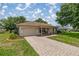 Attractive home featuring a paved driveway, covered porch, and lush landscaping at 11326 Se 175Th Pl, Summerfield, FL 34491