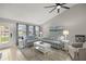 Inviting living room features tiled floors, a striped sofa, and large windows at 11326 Se 175Th Pl, Summerfield, FL 34491