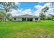 Expansive backyard with well-manicured lawn and a covered patio, offering a beautiful outdoor space for relaxation and recreation at 130 Nw 113Th Cir, Ocala, FL 34482