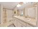 Bathroom featuring double sink vanity, granite countertops and shower with tile surround at 130 Nw 113Th Cir, Ocala, FL 34482