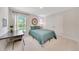 Well-lit bedroom with a green-covered bed, desk, and decorative wall art, creating a comfortable and stylish living space at 130 Nw 113Th Cir, Ocala, FL 34482