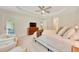 Spacious bedroom with tray ceiling, neutral carpet, backyard views, and access to the patio at 130 Nw 113Th Cir, Ocala, FL 34482