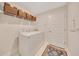 Functional laundry room with white washer and dryer, overhead storage baskets, and a decorative rug, blending practicality with style at 130 Nw 113Th Cir, Ocala, FL 34482