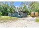 Inviting single-story home with blue siding, complemented by mature trees and a concrete driveway at 16082 Sw 24Th Pl, Ocala, FL 34481