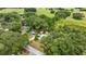 An aerial view showcases a home nestled amidst trees, a long driveway, and expansive lawn at 22535 Sw 117Th St, Dunnellon, FL 34431