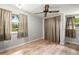 This bedroom has laminate floors, two windows, neutral paint and a ceiling fan with a light at 22535 Sw 117Th St, Dunnellon, FL 34431