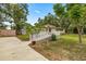 Image displays the home with an access ramp, extra storage buildings, and mature trees at 22535 Sw 117Th St, Dunnellon, FL 34431