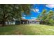 A gray house with windows is nestled within a serene backyard at 263 Chestnut Rd, Ocala, FL 34480