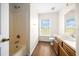 Bathroom features a shower and bath, a vanity, wood-style floors and a window with a pleasant view at 263 Chestnut Rd, Ocala, FL 34480