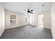 Bright bedroom with neutral carpet, ceiling fan, and two windows offering ample natural light at 263 Chestnut Rd, Ocala, FL 34480