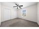 Bedroom features a ceiling fan and neutral carpet, complemented by natural light from the window at 263 Chestnut Rd, Ocala, FL 34480