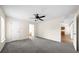 Spacious bedroom features a ceiling fan and neutral carpet, with an open doorway to the kitchen at 263 Chestnut Rd, Ocala, FL 34480
