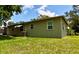 A view of the backyard featuring a well-kept lawn and an AC unit near the side of the home at 2810 Se Lake Weir Ave, Ocala, FL 34471