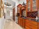 A built-in bar features wood cabinets, a wine fridge, granite countertops, and backsplash at 3986 Se 43Rd Cir, Ocala, FL 34480
